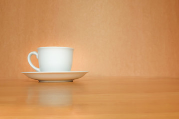 A white cup of coffee on wood background.