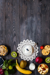 Healthy breakfast, cereal with yogurt, strawberries, blueberry, apple, banana, on rustic wooden.  Top view