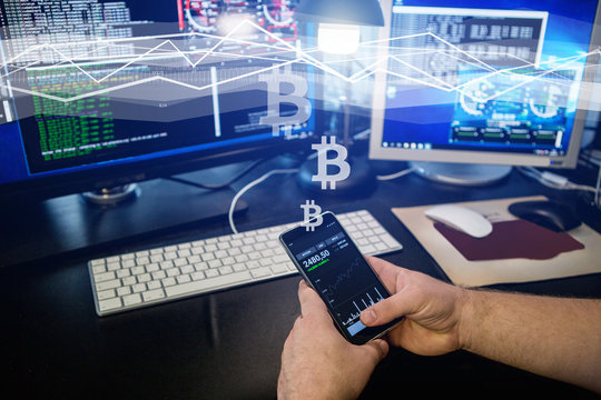 Man Holding A Phone With A Bitcoin Exchange Rate