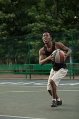 Fototapeta premium African american man plays on street basketball court. Real and authentic activity.
