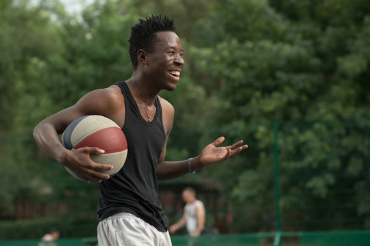African american man plays on street basketball court. Real and authentic activity.