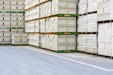 Piles of concrete blocks on wooden pallets stacked outdoors.