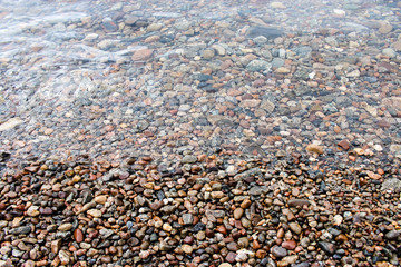 Pebbles on the seabed. Texture, background. Selective focus