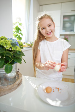 Kind schält Ei in der Küche