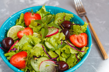 Bright summer salad of vegetables and berries. Love for a healthy vegan food concept.