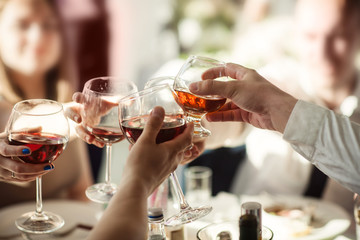 Glasses with wine and cognac in the hands