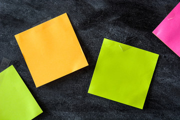 Colorful stick notes on blackboard background. Copyspace.

