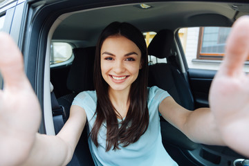 Gorgeous woman taking a picture of herself in car