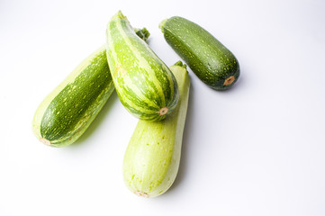 Zucchini, green summer squash on white