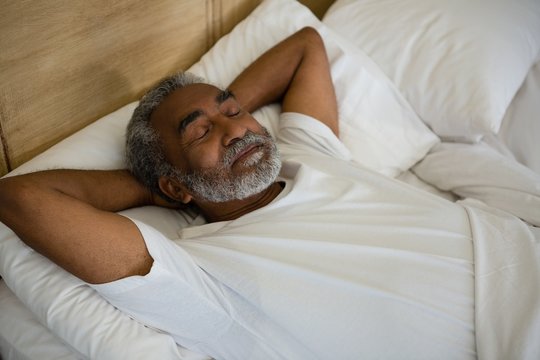 Senior man sleeping on bed in the bedroom