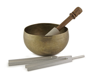 Sound healing therapy instruments - Tibetan Singing Bowl beside two different sized Tuning Forks isolated on a white background