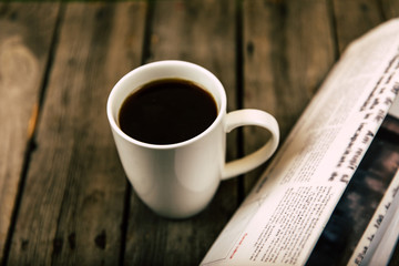 close up view of cup of coffee and newspaper