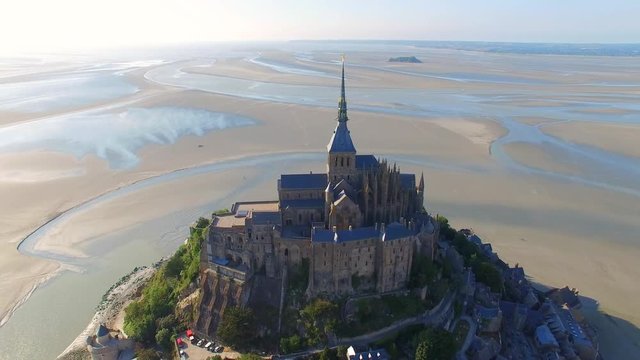 Aerial view of Mont Saint Michel, famous island and monastery protected by UNESCO at twilight, Normandy, France, 4k UHD 