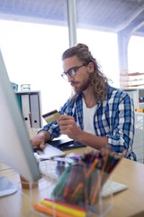 Male executive doing online shopping on laptop at his desk