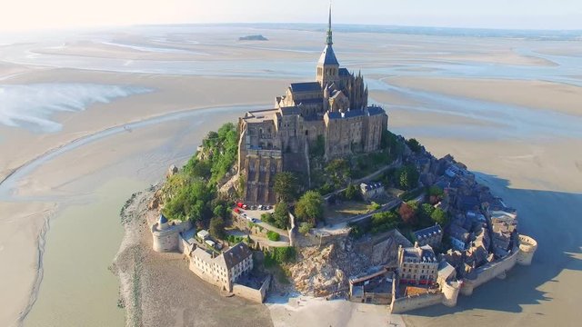 Aerial view of Mont Saint Michel, famous island and monastery protected by UNESCO at twilight, Normandy, France, 4k UHD 