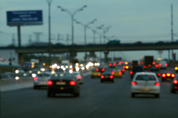 Fototapeta na wymiar Blurred background with lights of cars at dusk