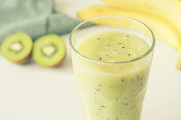 Glass of banana smoothie with kiwi.
