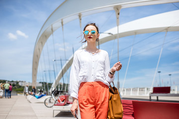 Elegant woman walking on the modern bridge in Lyon city