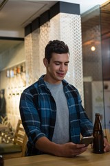 Fototapeta premium Man using mobile phone at bar