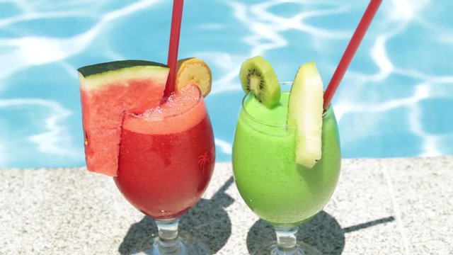 Cocktails on the background of the pool. Summer and rest. Two fruit cocktails.