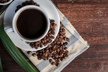 coffee cup and beans on the wood.