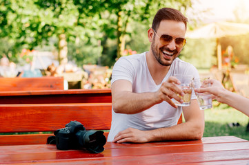 Happy friends drinking beer and clinking glasses at bar
