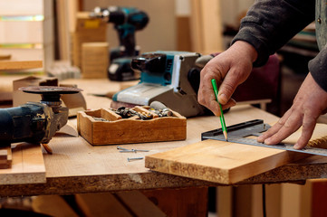 Carpenter's hands with pencil and try square .