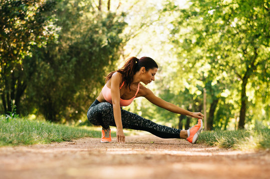 Young Sport Woman Exercising Before Jogging Outside In Nature