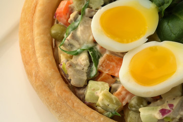 Olivier salad with eggs on white table. Close up