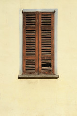 Detail of a window in a colorful wall, warm Italian sunlight and the real mediterranean atmosphere