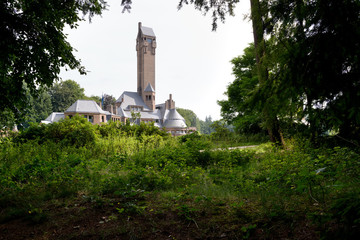 Lodge St. Hubertus, shot from behind some trees, at National Park De Hoge Veluwe, The Netherlands.