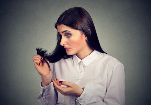 Unhappy frustrated woman surprised she is losing hair, noticed split ends