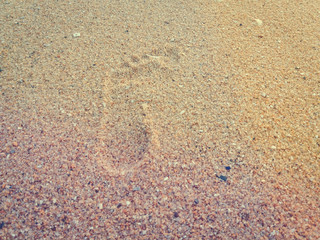 Natural background of human footprint in the wet sandy seaside. Close-up photography on relaxation sign idea design