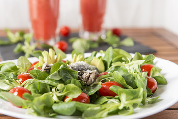 Ensalada de canónigos, con aguacates, sardinas y tomate