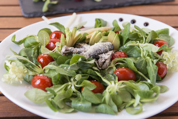 Ensalada de canónigos, con aguacates, sardinas y tomate