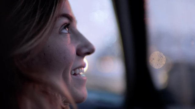 Slow Motion Closeup Of Young Woman Laughing And Looking Out Car Window At Night