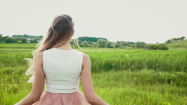 Young woman swinging her bautiful hair on the summer meadow slow motion
