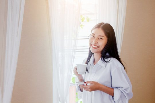 Woman drinking coffee in bedroom