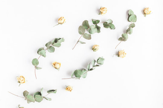 Flowers composition. Pattern made of rose flowers and eucalyptus branches on white background. Flat lay, top view