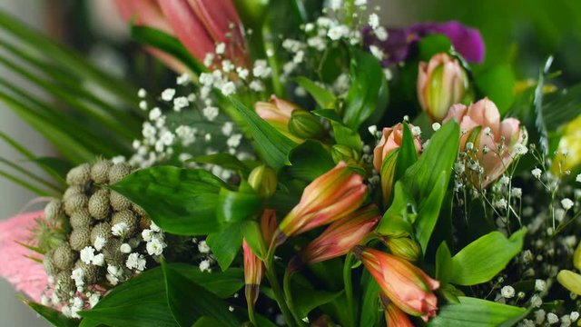 close-up, Flower bouquet in the rays of light, rotation, the floral composition consists of calla, lily, Brunia green, gypsophila, Orchid vanda, Alstroemeria, aspidistra, Russus,