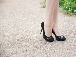 Female feet in shoes on a path in the park