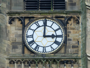 Fototapeta na wymiar church clock white face with roman numerals at three o clock in the church in huddersfield
