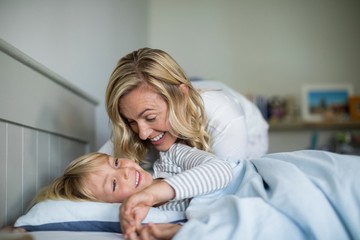 Fototapeta premium Mother and son having fun together in the bedroom
