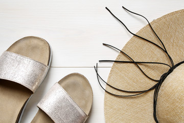 straw hat and beach slippers- summer accessories on wooden background