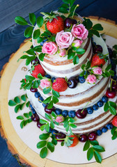 Obraz na płótnie Canvas Naked wedding cake decorated with berries and flowers