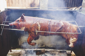 Whole pig roasting at open fire