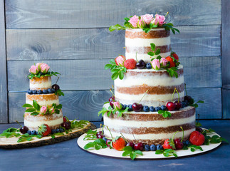 Naked wedding cake decorated with berries and flowers