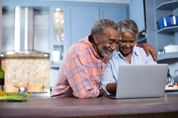 Smiling couple using laptop computer