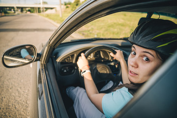 woman driving car in helmet with horror on her face