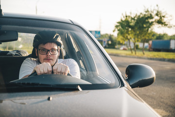 man driving car in helmet with horror on her face